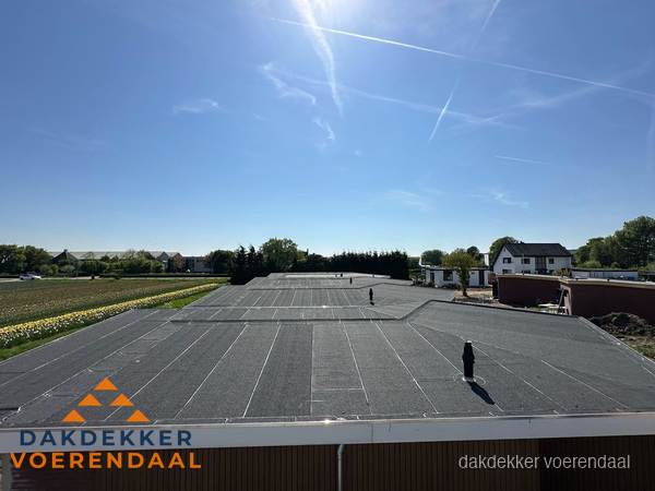 Groot plat dak met bitumen dakbedekking op bedrijfspand in Voerendaal Groot plat dak met bitumen dakbedekking op bedrijfspand in Voerendaal