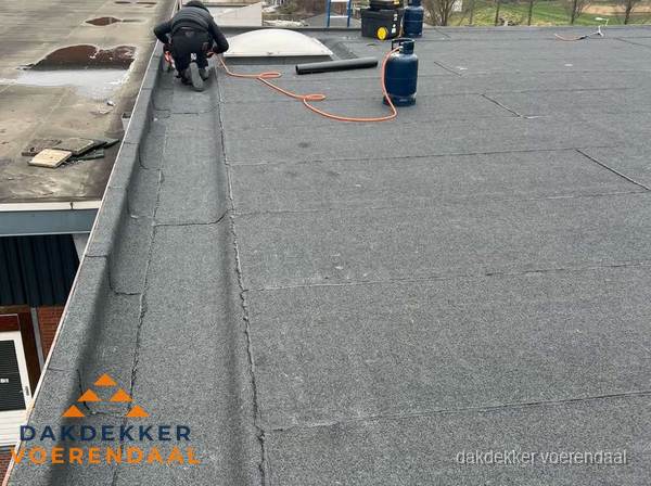 Dakdekker repareert bitumen dakbedekking op groot plat dak in Voerendaal Dakdekker repareert bitumen dakbedekking op groot plat dak in Voerendaal