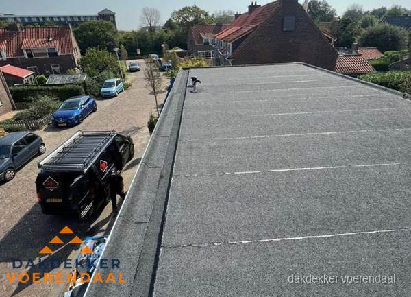 Nieuw bitumen plat dak met uitzicht over woonwijk in Voerendaal Nieuw bitumen plat dak met uitzicht over woonwijk in Voerendaal